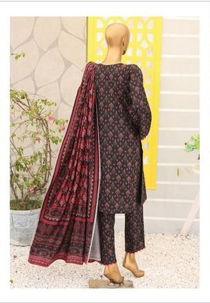 Woman wearing a dark red and black patterned outfit with a matching dupatta in an indoor setting.